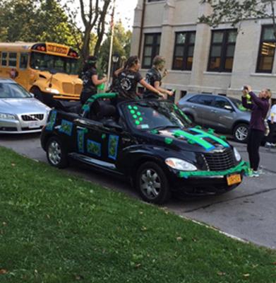 another angle of students piled in a hornet themed car